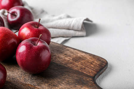 Board with fresh red apples on light backgroundの写真素材