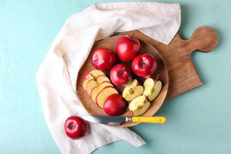 Tray with fresh red apples and knife on color backgroundの写真素材
