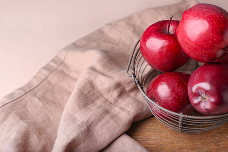 Basket with fresh red apples on color backgroundの写真素材