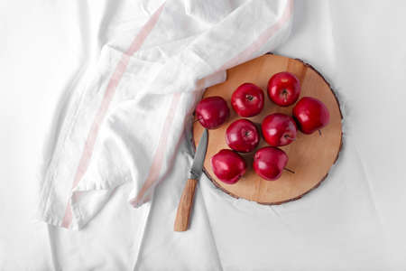 Board with fresh red apples and knife on tableの写真素材