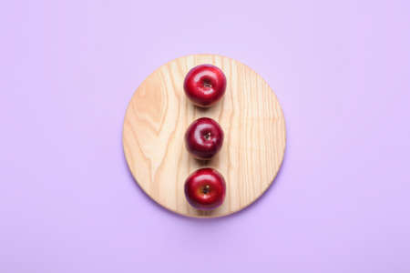 Board with fresh red apples on color backgroundの写真素材