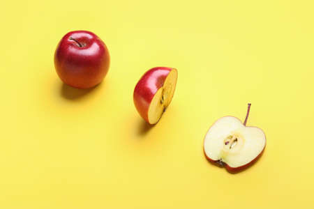 Fresh red apple with different pieces on color background