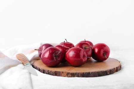 Board with fresh red apples and knife on tableの写真素材
