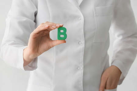 Female doctor with letter B on light background, closeupの写真素材