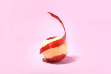 Peeled red apple on color background