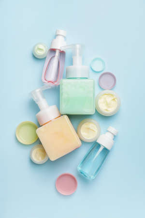 Different bottles of cosmetic products on color backgroundの写真素材