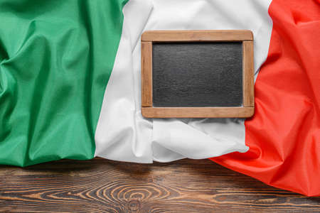 Italian flag and empty chalkboard on wooden backgroundの写真素材