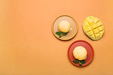 Plates with tasty mango ice cream on color backgroundの写真素材
