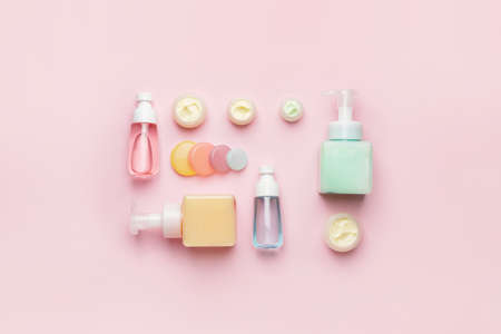 Set of bottles with cosmetics products on color background
