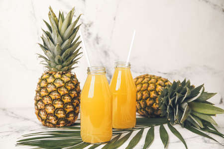 Bottles of fresh pineapple juice on white backgroundの写真素材