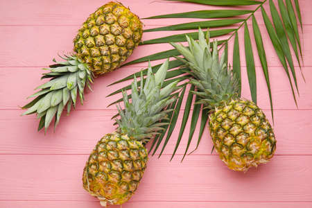 Fresh pineapples on color wooden backgroundの写真素材