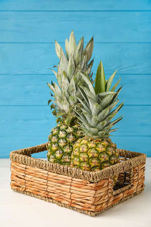 Basket with fresh pineapples on tableの写真素材