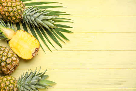 Fresh pineapples on color wooden backgroundの写真素材
