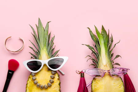 Pineapples with female accessories on color backgroundの写真素材