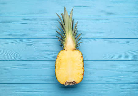 Half of fresh pineapple on color wooden backgroundの写真素材