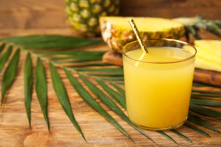 Glass of fresh pineapple juice on tableの写真素材