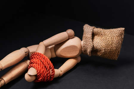 Mannequin with sack on head and hands tied with rope on dark background. Concept of hostageの写真素材