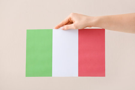 Female hand with national flag of Italy on light backgroundの写真素材