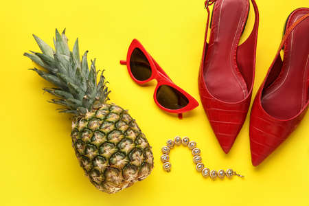 Pineapple with female accessories on color background