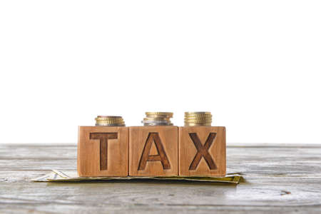 Word TAX with money on table against white backgroundの写真素材