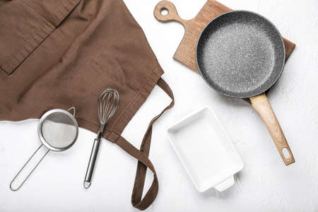 Apron and set of kitchen utensils on light backgroundの写真素材