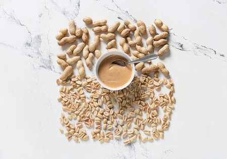 Bowl with tasty peanut butter and nuts on white backgroundの写真素材