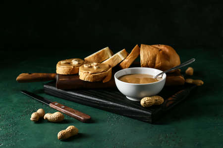 Tasty peanut butter and bread on tableの写真素材