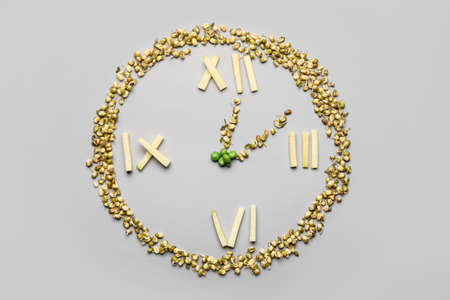 Clock made of food on gray background