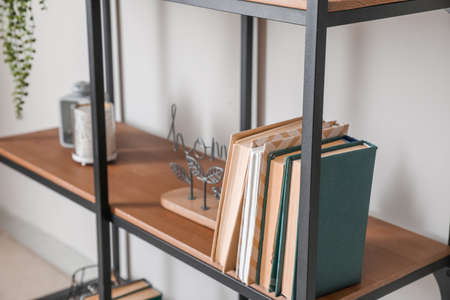 Modern shelf with books and decor near white wall, closeupの写真素材