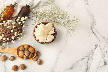 Composition with shea butter, nuts and essential oil on light backgroundの写真素材