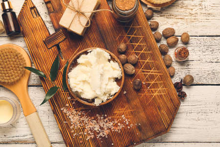 Composition with shea butter, nuts and bath supplies on light wooden backgroundの写真素材