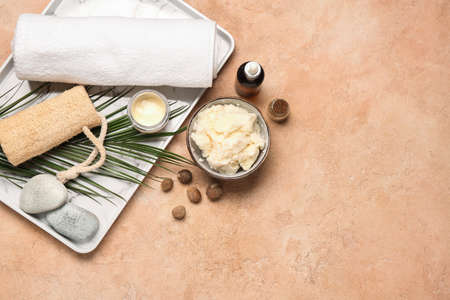 Bowl with shea butter, essential oil and bath supplies on color backgroundの写真素材