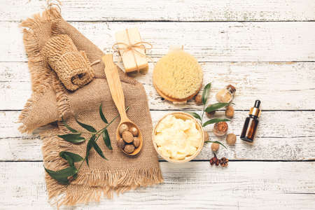 Composition with shea butter, nuts and bath supplies on light wooden backgroundの写真素材