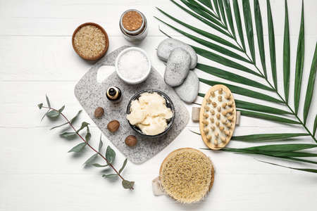 Bowl with shea butter, nuts and bath supplies on light backgroundの写真素材