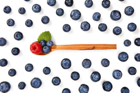 Wooden spoon with tasty ripe berries on white background
