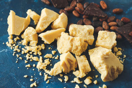 Cocoa butter, chocolate and beans on color background, closeupの写真素材