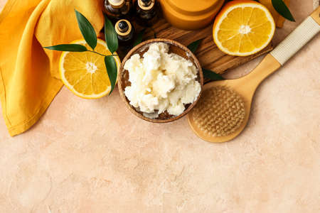 Composition with shea butter, orange fruits, brush and cosmetic products on color backgroundの写真素材