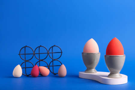 Creative composition with egg holders and makeup sponges on color backgroundの写真素材
