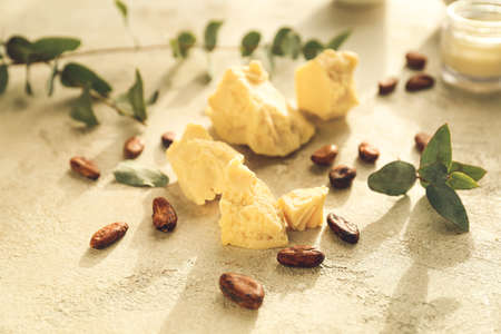 Cocoa butter and beans on light background, closeupの写真素材