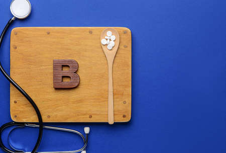 Letter B with stethoscope and pills on color backgroundの写真素材