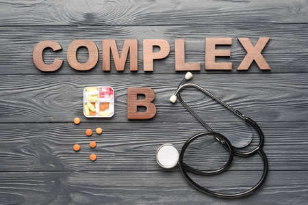 Text COMPLEX B with stethoscope and pills on dark wooden backgroundの写真素材