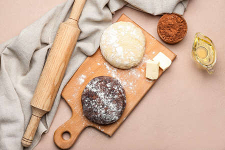 Fresh dough with ingredients for preparing bakery and utensils on color backgroundの写真素材