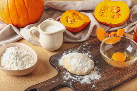 Ingredients for preparing bakery with pumpkin on color background