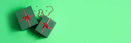 Beautiful Christmas gifts on green background with space for textの写真素材