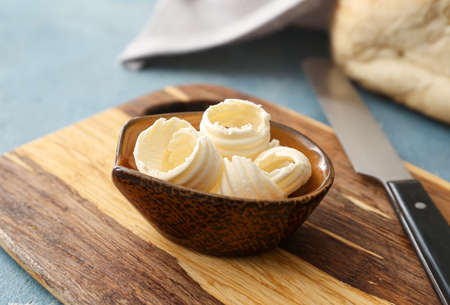 Bowl with fresh butter on wooden background, closeupの写真素材