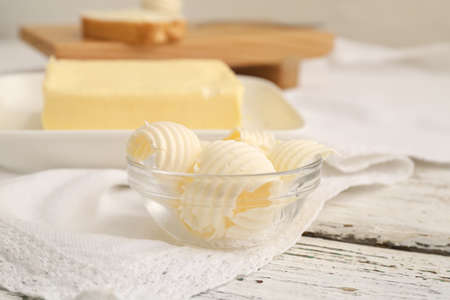 Bowl with fresh butter on light wooden backgroundの写真素材