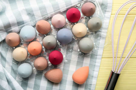 Creative composition with makeup sponges and whisk on color wooden backgroundの写真素材