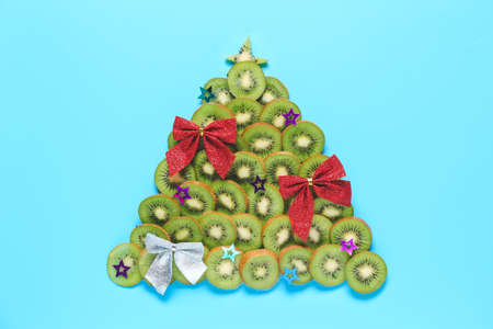 Christmas tree made of ripe kiwi on color backgroundの写真素材