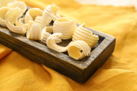 Butter curls in wooden plate on fabric backgroundの写真素材