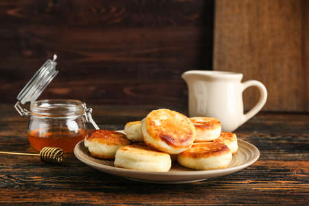 Plate with tasty cottage cheese pancakes on tableの写真素材